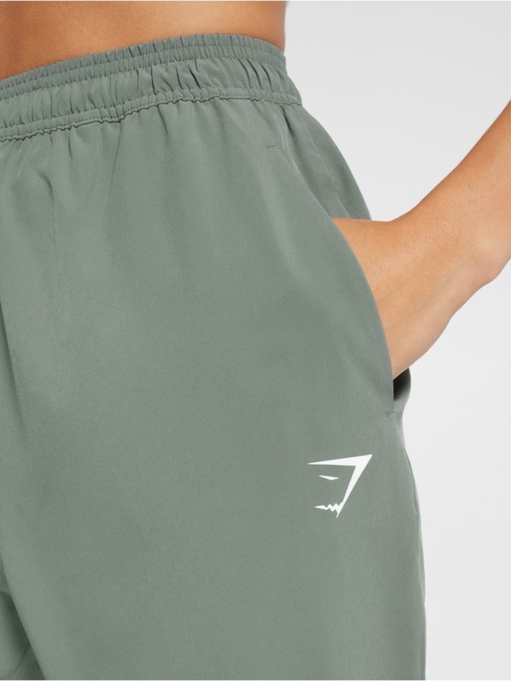 Gymshark Training Woven Joggers in a green color, designed for versatile workout